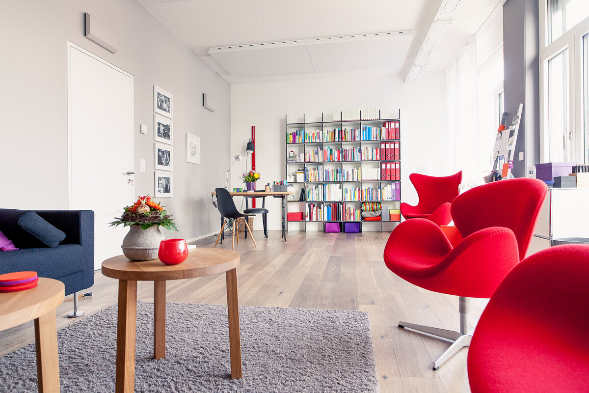 Der Mensch im Zentrum Die Einrichtung der Unternehmensräume erfolgte unter Kriterien, die Wohlfühlen und Strahlkraft erzeugen. Moderne Klassiker in bunten Farben, klassisches Schwarz-Weiß und die Wärme von Holz harmonieren hier bestens miteinander.